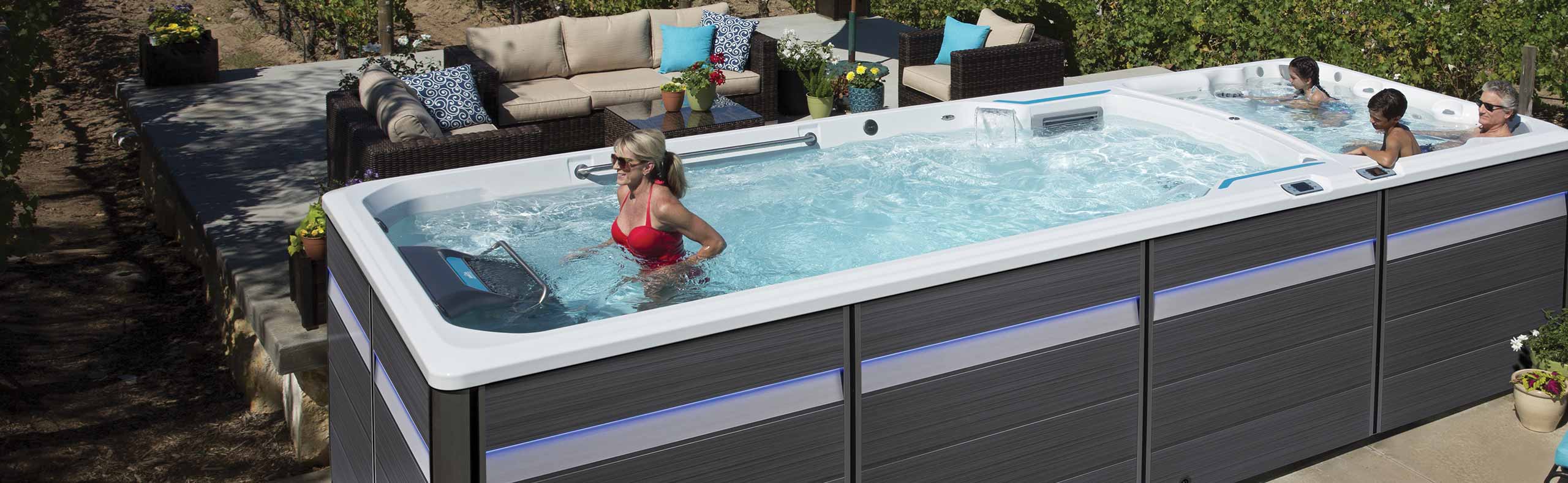 woman using treadmill in a swim spa with family in hot tub section