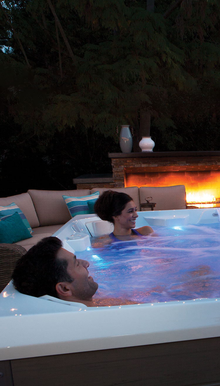 people in a hot tub in a backyard