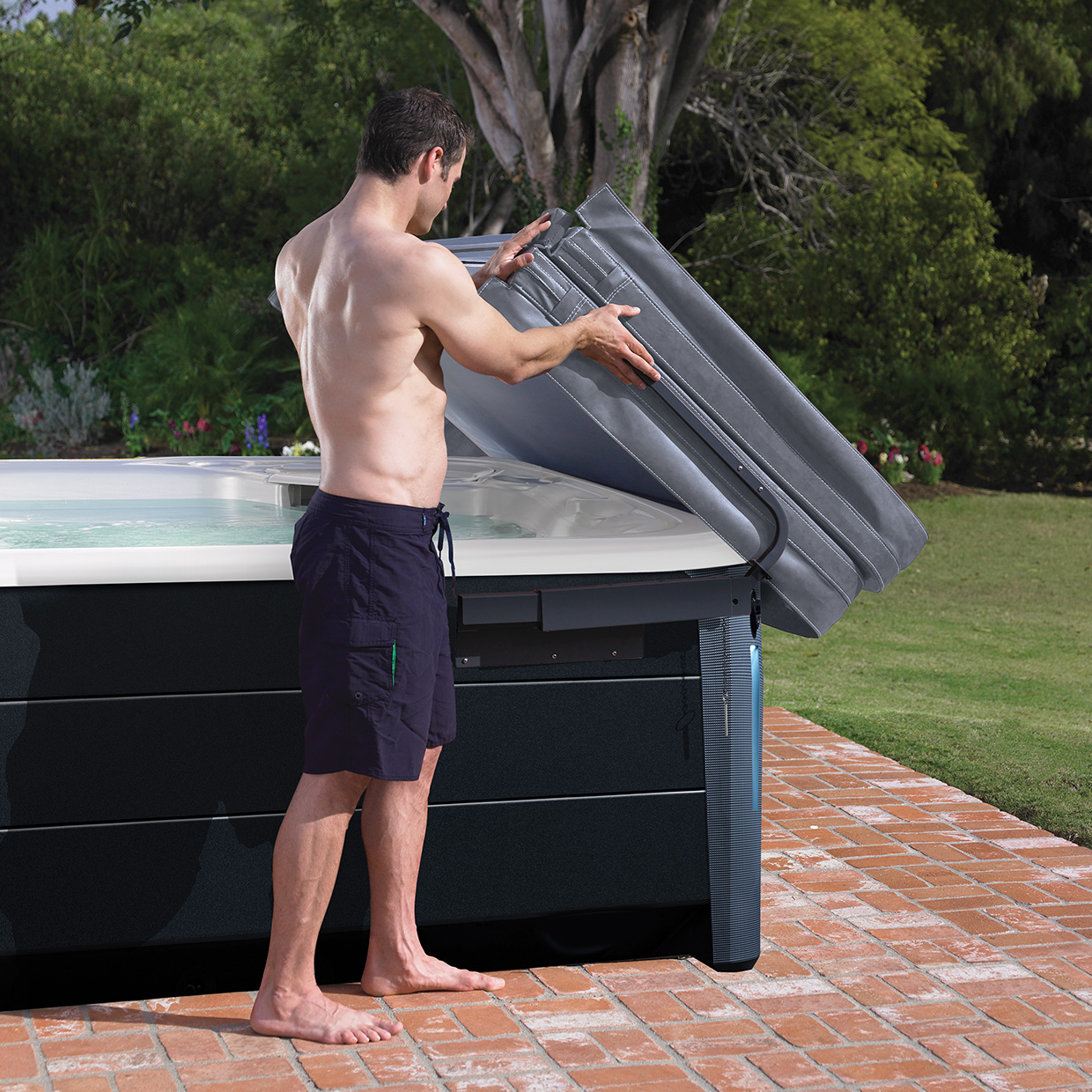 man removing the Lift n Glide cover from a hot tub